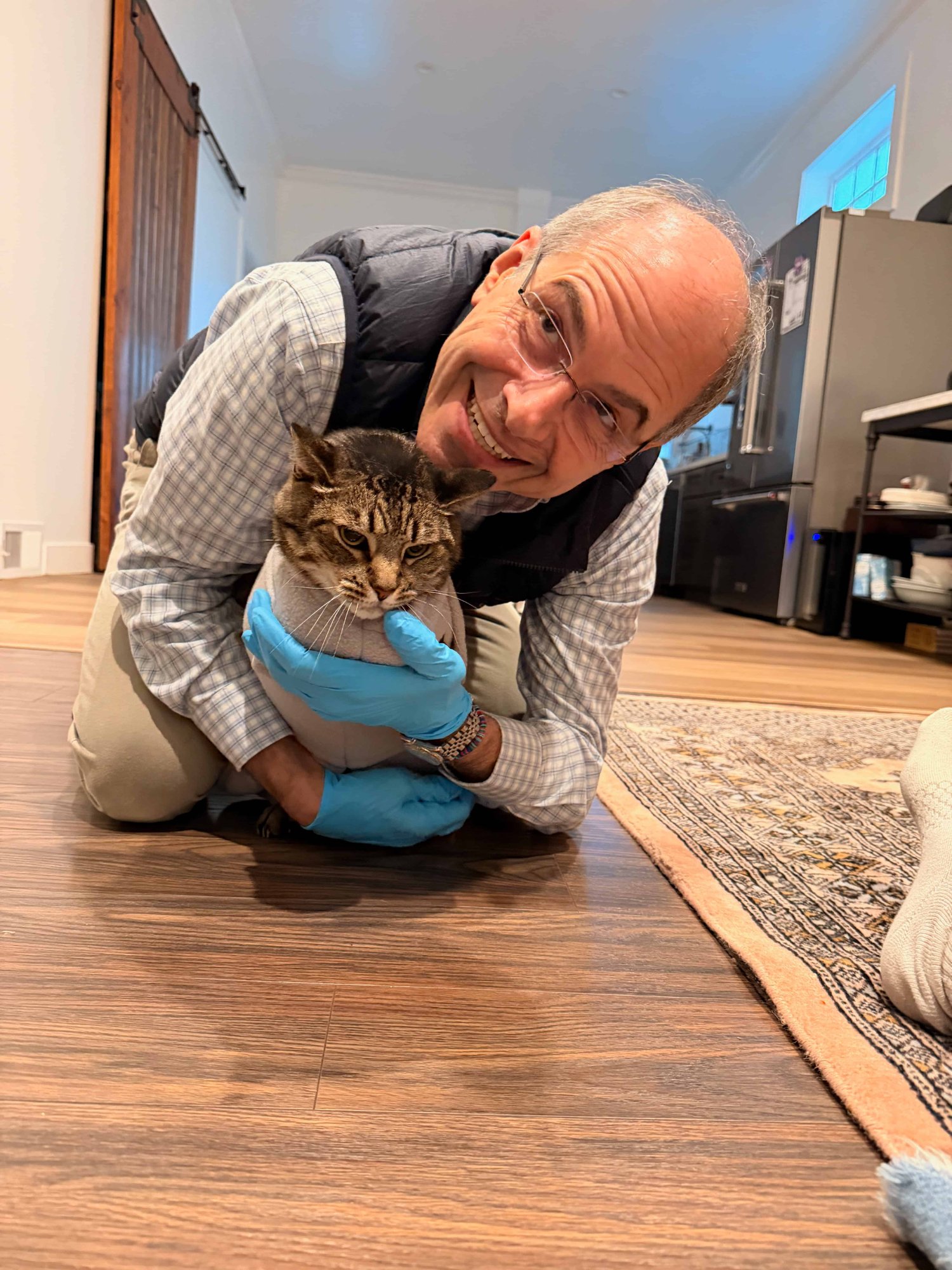 Dr. Behrens examining a cat on the floor